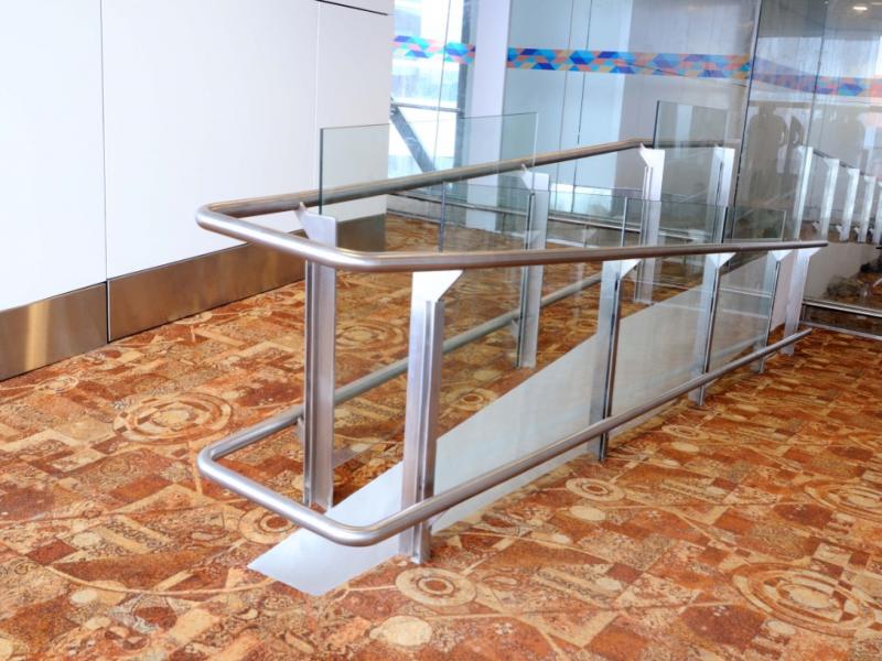 Stainless steel top Handrail connected with offset stems to stainless steel flat balustrade with ofset holders supporting 10mm glass. This also has in-built Skirt rail.